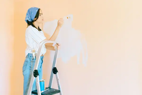 Interior painting in Baton Rouge: painter on a stepladder rolling a wall